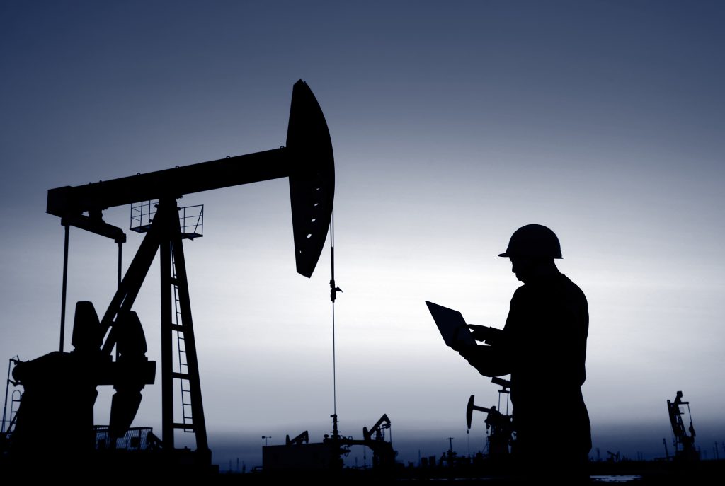 Workers on tablet in Oil field