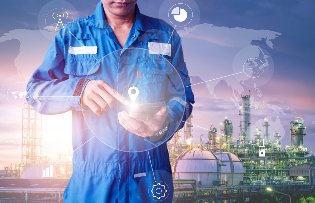 Engineer stand holding hand touch of smart phone on oil and gas refinery plant background, Engineer planning work concept, Professional technician monitoring of petrochemical industry plant