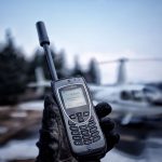 Iridium Satellite Phone with Helicopter blurred in background