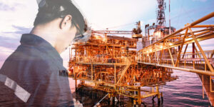 Worker on oil rig platform using digital communication equipment